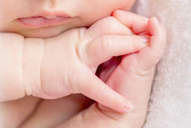 一个熟睡的新生婴儿手指交叉，特写
