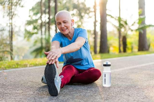 Woman cancer survivor exercising outdoors in a park