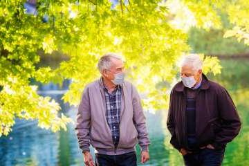 two elderly men with masks in the park